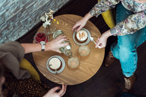 Table with coffee and female hands — Stock Photo, Image