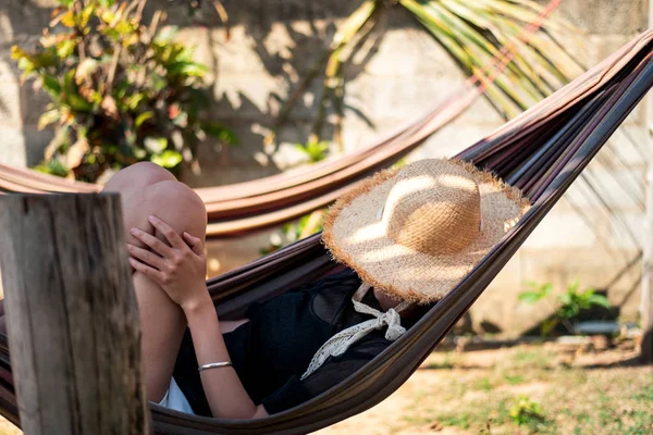Žena relaxuje v houpací síti na pláži — Stock fotografie