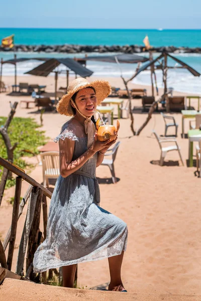 Kobieta z kokosem na tropikalnej plaży — Zdjęcie stockowe