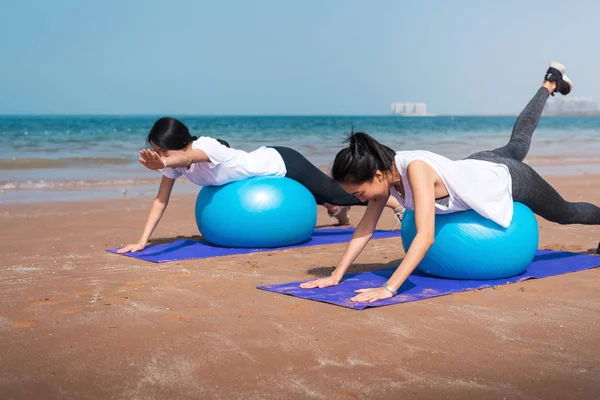 Donne che si allenano con la palla pilates sulla spiaggia — Foto Stock