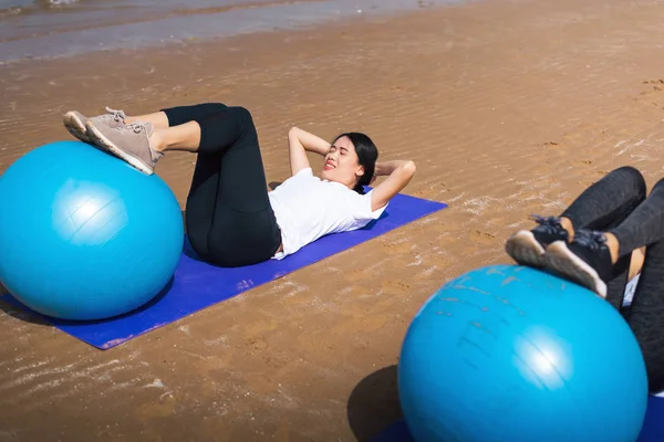 Plajda pilates topuyla egzersiz yapan bir kadın. — Stok fotoğraf