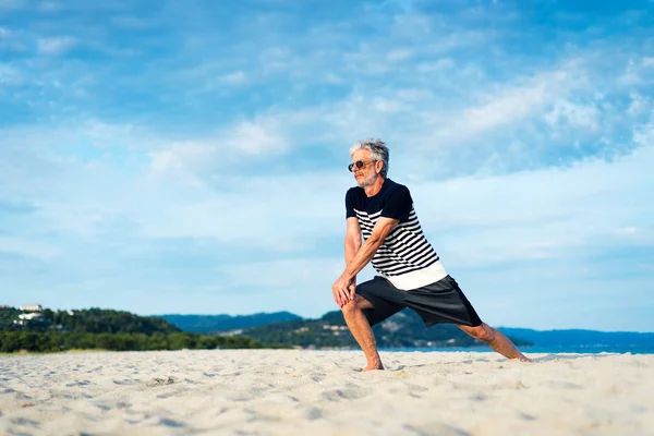 Uomo anziano che si esercita sulla spiaggia — Foto Stock