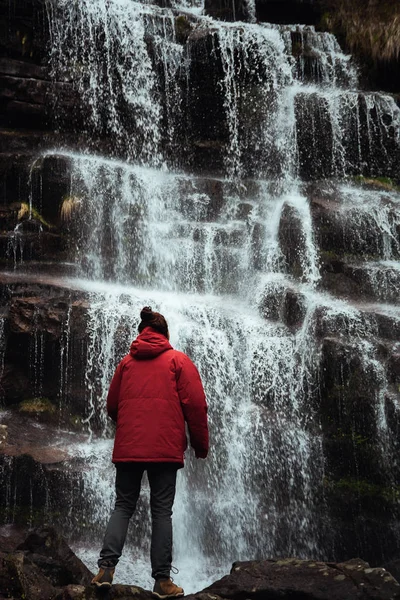 Fille en veste rouge près de la cascade — Photo