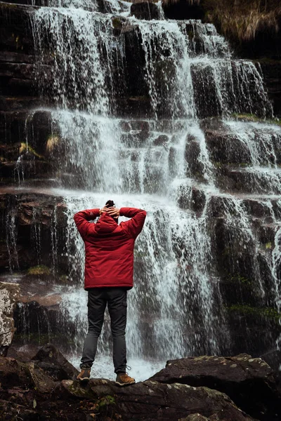 Dívka v červeném plášti u vodopádu — Stock fotografie