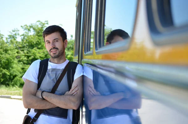 Joven apoyado en un autobús — Foto de Stock