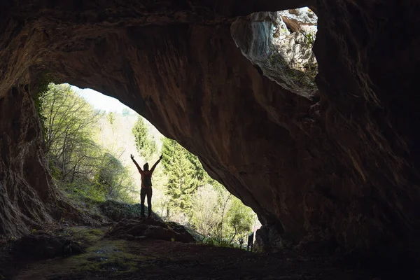 Девушка у входа в пещеру — стоковое фото