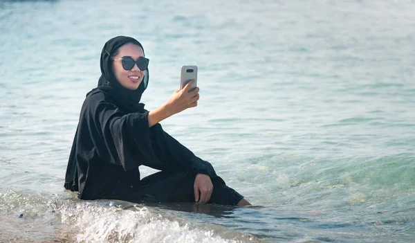 Muszlim nő vesz selfie a tengerparton — Stock Fotó