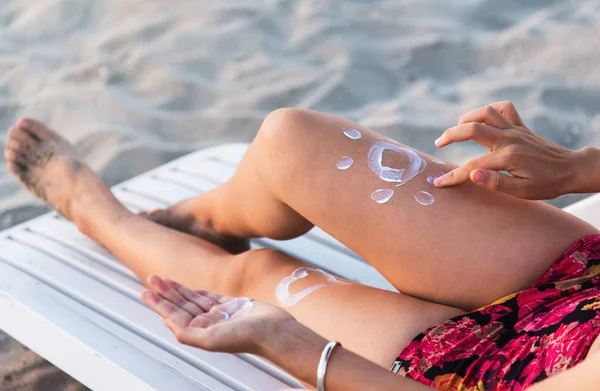 Женщина, использующая солнечный лосьон на пляже — стоковое фото