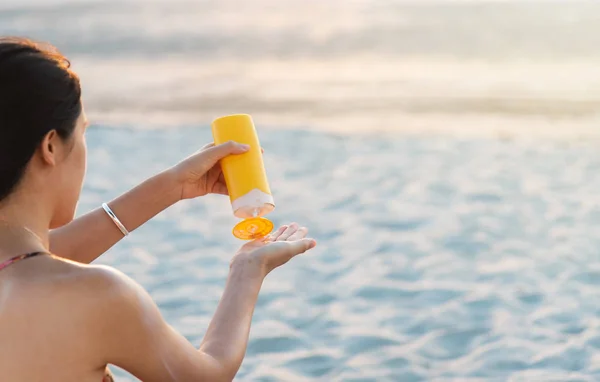 Woman using sun lotion on the beach — Stock Photo, Image