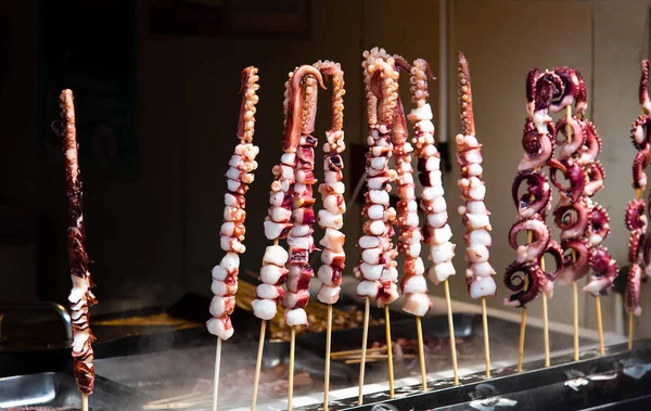 Pezzi di calamari grigliate alimentari pronte sul mercato alimentare — Foto Stock