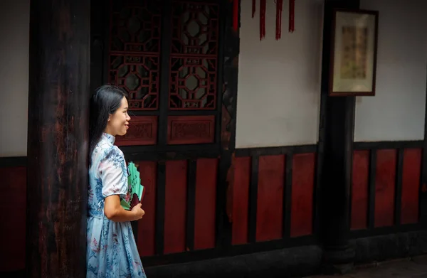 Asian woman in a temple holding a hand fan — Stock Photo, Image