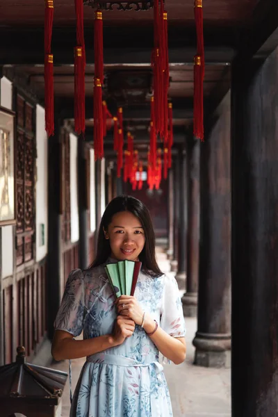 Asiatische Frau in einem Tempel mit einem Handfächer — Stockfoto