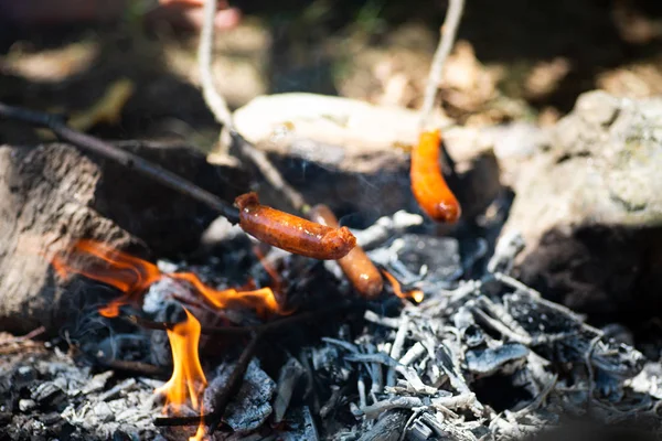 La gente cuoce salsiccia in fiamme su un picnic — Foto Stock