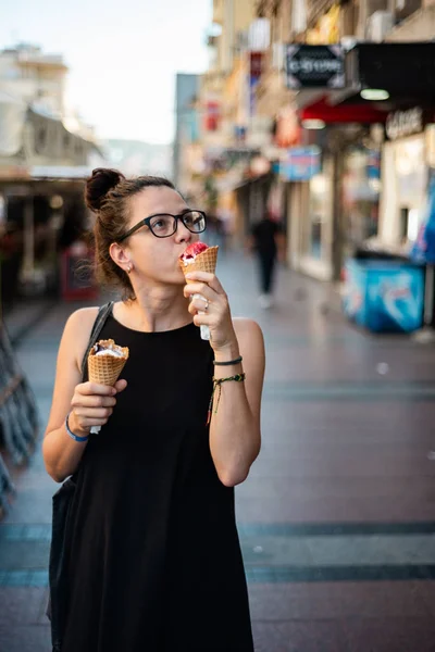 Menina comendo dois sorvetes na rua — Fotografia de Stock