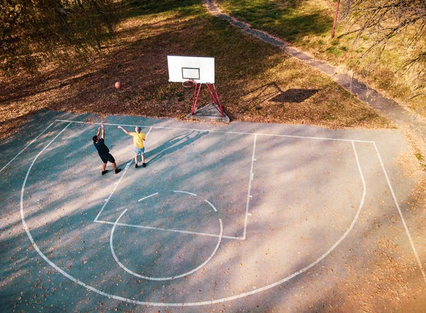 Батько і син грають у баскетбол у парку — стокове фото