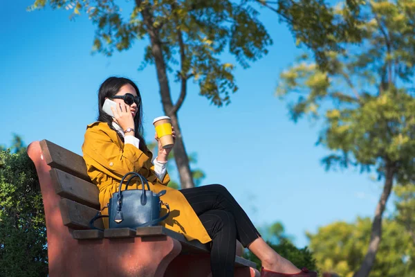 Telefonu kullanan ve kahve içen bir kadın. — Stok fotoğraf