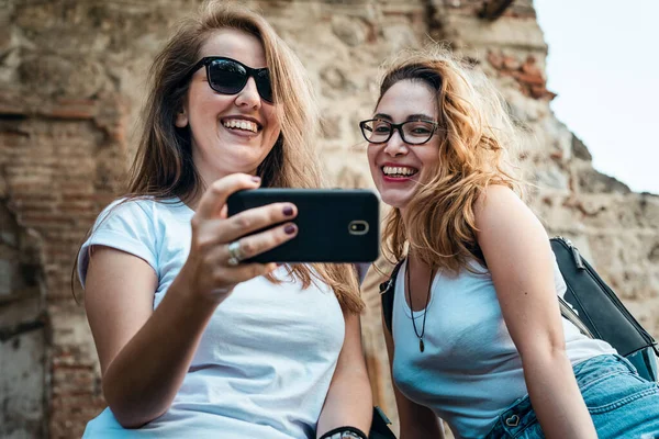 Duas raparigas a olhar para um telemóvel — Fotografia de Stock