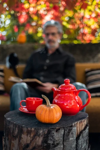 Öreg ember teát iszik és könyvet olvas — Stock Fotó