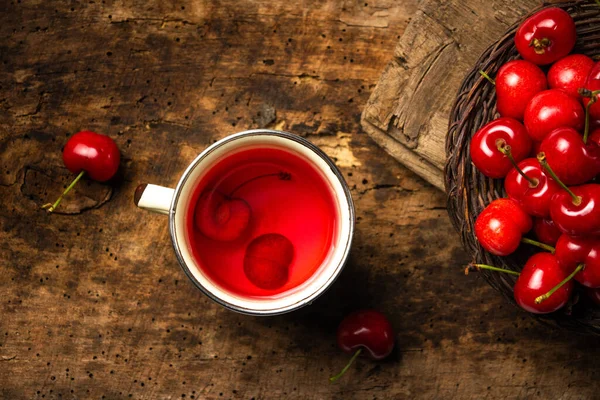 Kirschtee mit Früchten auf einem rustikalen Tisch — Stockfoto