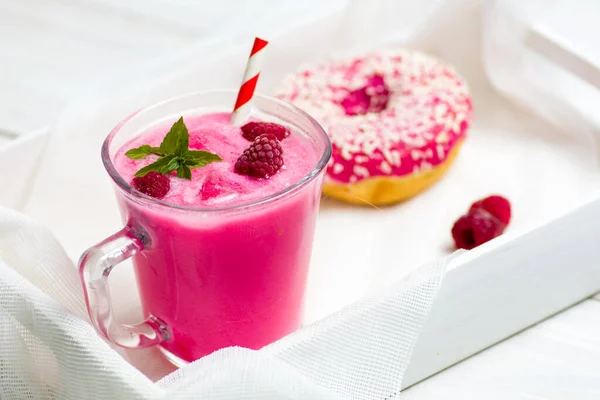 Малиновый смузи и розовый пончик — стоковое фото