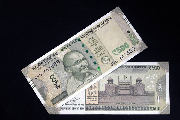 Indian currency. 500 rupee note with Indian coins. Indian currency isolated on black background.