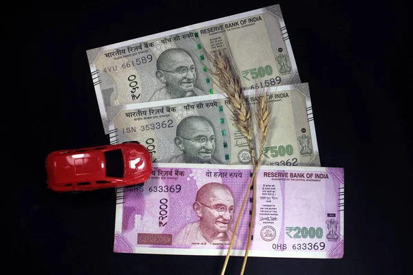 新しいインド通貨 小麦粒と赤い色のおもちゃの車で500 および2000ルピーノート 黒の背景に孤立したインド通貨 — ストック写真