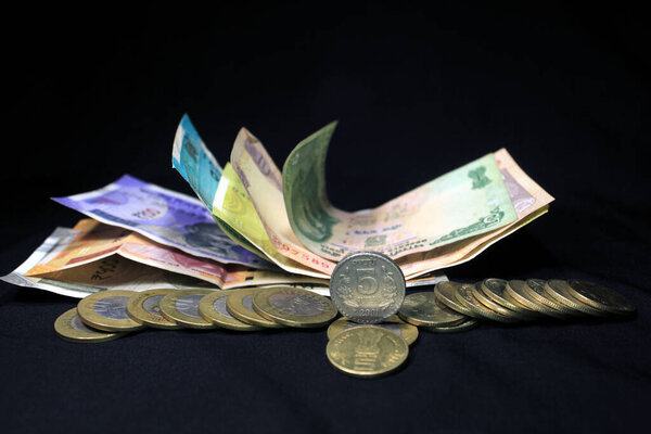 Сейчас и старые индийские валюты. 50, 100, 200, 500 рупий банкнот и монет. Индийская валюта на черном фоне.