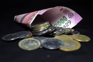 Yeni Hint parası. Bozuk paralarla 2000 rupi. Siyah arkaplanda izole edilmiş Hint para birimi.
