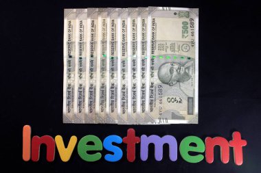 Yeni Hint para birimi 500 rupi. Siyah arka planda izole edilmiş kalem ve not defteriyle 500 rupi Kızılderili parası. Yatırım kavramı.