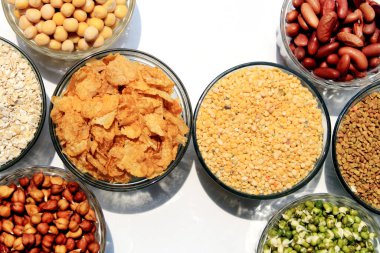 Beyaz zemin üzerinde bulunan baklagil koleksiyonu (nohut, yeşil bezelye, pembe mercimek, Hint mercimeği, kırmızı fasulye, yeşil mung fasulyesi, kuru bezelye, Güvercin Bezelyesi, Kırmızı Böbrek, Fenugreek Tohumu, Yulaf ezmesi).