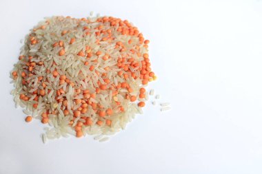 Pişmemiş çiğ pirinç taneleri, kırmızı mercimek. Beyaz arkaplanda pirinç taneleri ve kırmızı mercimek izole edilmiş..