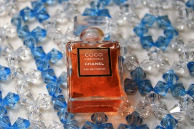 Paris, Fransa 13 Mayıs 2020: Chanel parfüm şişeleri kırmızı arka planda izole edildi. Kadın aksesuarlarıyla farklı Chanel parfüm ürünleri..