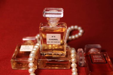 Paris, Hindistan, 13 Mayıs 2020: Chanel parfüm şişeleri kırmızı arka planda izole edilmiş mücevherler. Farklı Chanel parfüm ürünleri olan şişeler..