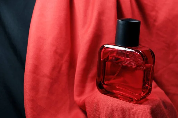 赤い絹の背景に隔離された赤い色の男性香水瓶 ブラックキャップ 天然スプレー付きの赤い香水瓶 — ストック写真
