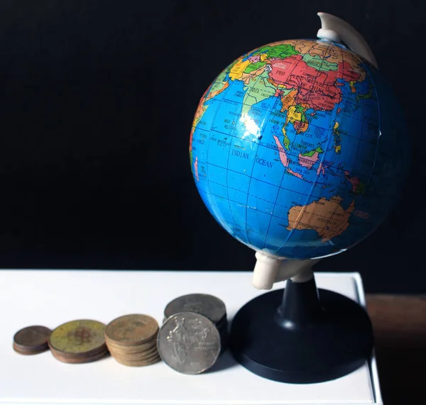 地球地図で黒の背景にインドのコインのスタック ビジネスの比喩 金融投資と経済の概念 バーにおけるインドコインのスタック — ストック写真