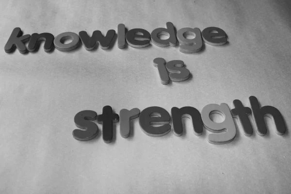 knowledge is strength. Knowledge is strength written on wall by using the wooden English alphabet.