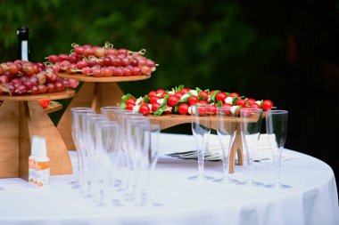 Stand-up yemeği şampanyalı İsveç masası ve aperatifler ve çilek ve üzüm meyveleri