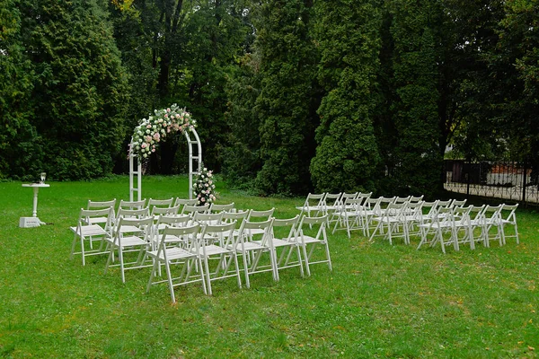 A festive decor of wedding arch is floral composition. Zone of wedding ceremony on nature.