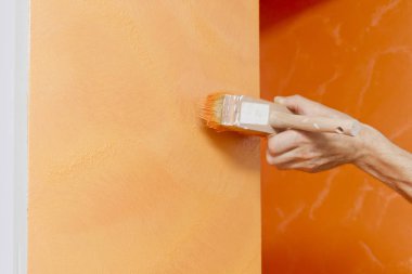 el boyama işçinin yapısal boya duvar üzerinde inflicting turuncu