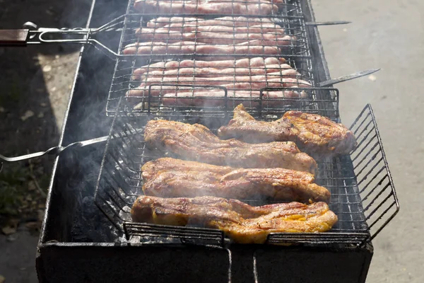 Cooking meat and sausages on the grill. — Stock Photo, Image