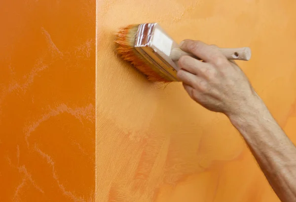 手绘工人橙色的手造成在墙上的结构油漆 — 图库照片#