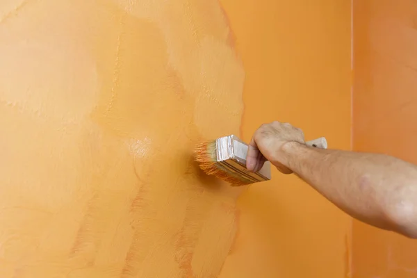 手绘工人橙色的手造成在墙上的结构油漆 — 图库照片#