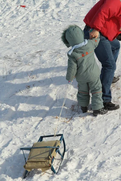 孩子与父亲拉扯雪橇在雪山 — 图库照片