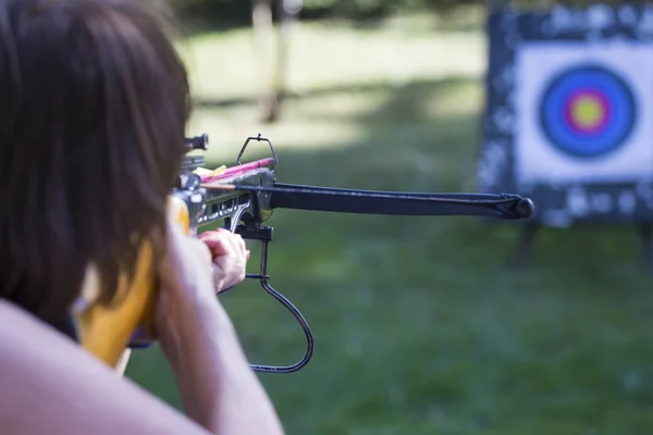 Archer dengan busur panah arbalest dengan panah siap untuk memukul target di bullseye di kereta api — Stok Foto