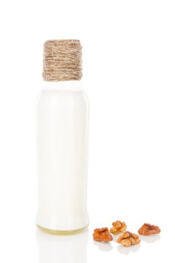 A bottle of milk cocktail shake yoghourt with peeled walnuts white background isolated