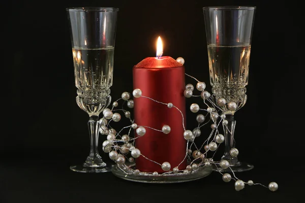 Two Glasses Champagne Burning Red Candle Wreath Black Background — Stock Photo, Image