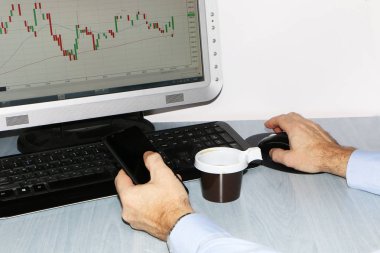 Yakın çekim-tablo bir monitör için bir bilgisayar, bir fincan kahve, bir akıllı telefon, bir hisse senedi grafiği