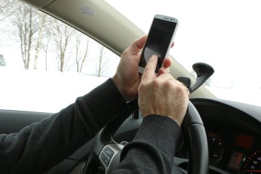 sürücü direksiyonda kahve içer, sıcak dock yiyor ve telefonda konuşuyor