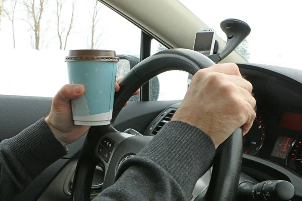 sürücü direksiyonda kahve içer, sıcak dock yiyor ve telefonda konuşuyor