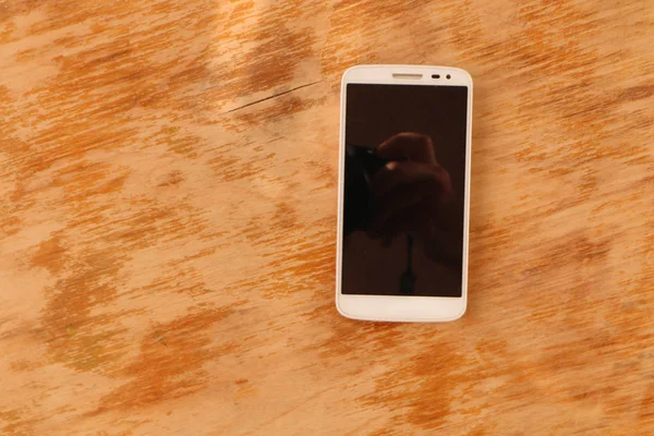 Beyaz Bir Smartphone Eski Bir Ahşap Zemin Üzerine Siyah Bir — Stok fotoğraf